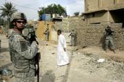 An Iraqi man walks past as U.S. soldiers from Alpha Company 1-17 Battalion of the 172th Stryker Brigade combat team patrol in eastern Baghdad, Iraq. The U.S military has been performing scout missions aimed at preparing security operations to stop sectarian violence in the capital.