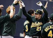 Oakland's Mark kotsay (21) accepts congratulations on his two-run inside-the-park home run. The Athletics defeated the Minnesota Twins, 5-2, on Wednesday in Minneapolis.