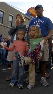 Lawrence residents front left, Bailey Sarna, 6, and Abby Monroe, 5, and Jerlyn and Michael Monore cheer along with the Rock Chalk dancers, the KU Cheerleaders and others while a block party was held to help promote KU's Homecoming game against Texas A & M at 11 a.m. tomorrow at Memorial Stadium.