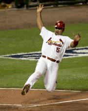 St. Louis' Albert Pujols slides into home to score on Juan Encarnacion's triple. St. Louis elimated the Padres in Game 4, 6-2, Sunday in St. Louis.