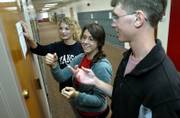 Lawrence High School seniors, from left, Kate Mather, Julia Barnard and Sam Huneke hang "Promote the Vote" fliers Monday. The Young Democrats members are helping organize a voter registration, which will be Sunday at the South Park gazebo.
