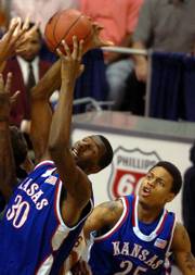 Kansas' Julian Wright, left, comes down with a rebound in front of teammate Brandon Rush in this file photo from last season's KU-Texas contest in the Big 12 Conference tournament championship game. Wright and Rush on Wednesday were named Big 12 co-players of the year.