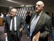 Kansas University chancellor Robert Hemenway, left, and athletic director Lew Perkins visit with an audience member following a news conference concerning the NCAA's response to infractions committed by KU. Hemenway and Perkins discussed the NCAA-imposed penalties Thursday at Hadl Auditorium.