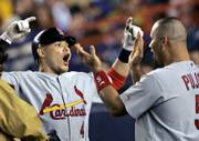 St. Louis' Yadier Molina, left, celebrates with Albert Pujols after hitting a two-run, ninth-inning homer. The blast was decisive in the Cardinals' 3-1 victory Thursday night in New York.