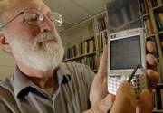 Gary Minden, professor of electrical engineering at Kansas University, demonstrates the capabilities of his new Hewlett-Packard 6945, which has many wireless options and is similar to the new 3G phones soon to hit the consumer market.