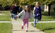 Kindergartners Lydia Wood, 5, and Katie Babbit 6, skip on their way home Monday from Deerfield School. Revised estimates from the U.S. Census Bureau show that Douglas County's population is 111,519, which is 9,000 higher than a previous challenged estimate.