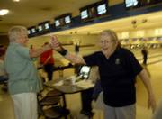 Rusty Moore, Lawrence, left, high-fives Penny Fowler, Lawrence, after Fowler picked up a spare during their bowling league action at Royal Crest Lanes, 933 Iowa. Fowler moved to Lawrence from Florida in 2003 to be near her daughter.