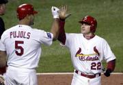 St. Louis' David Eckstein (22) high-fives Albert Pujols after scoring a run. The Cardinals defeated Detroit, 5-4, on Thursday night in St. Louis to take a 3-1 lead in the World Series.