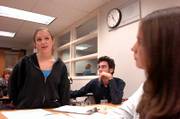 Lawrence High School senior Lexie Welch, left, and LHS junior Sarah Ybarra, right, have raised concerns about military recruiters in their high school and the accompanying school district policy. Welch and Ybarra, who are producing a documentary about the subject, are shown Thursday at the school with teacher Jeff Kuhr.