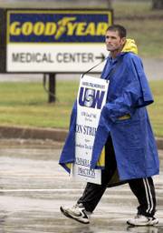 Bill Brown, a Goodyear Tire & Rubber Co. employee, walks the picket line at the front gate of the factory earlier this month in Tyler, Texas. Goodyear said Monday that it plans to close the Tyler plant three weeks after workers at the plant and 15 others went on strike.