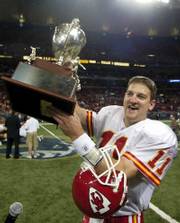 Kansas City's Damon Huard hoists the Missouri Governor's Cup. Huard threw three touchdowns Sunday in St. Louis.