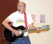 Stan Slaughter, also known as the Eco Troubadour, entertains children at Edith Scheuerman Elementary School in Garden City. As an employee of the Kansas Department of Health and Environment, Slaughter travels to schools and uses music to teach students about recycling.