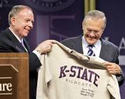 Kansas State University President Jon Wefald, left, presents Defense Secretary Donald Rumsfeld with a shirt after his Landon Lecture Thursday in Manhattan. Rumsfeld spoke a day after resigning.