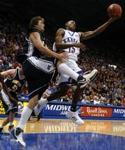 Kansas guard Mario Chalmers flips extends for a shot behind the back over Northern Arizona forward Kyle Landry during the second half of Saturday night's game against the Lumberjacks at Allen Fieldhouse.