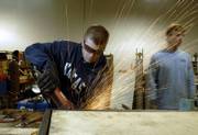 Austin Berke, Kansas University architecture student from Stilwell, grinds down a weld on a metal frame, which is part of a large collapsible community stage the class is building for the Seventh Ward in New Orleans. Students worked on the project Friday in a warehouse on KU's west campus.