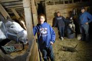 Jeffery Kirk, 11, left, helps his family finish some evening chores by feeding their horses. In the background are, from left, Jeffery's mother, Anne; his brother, Steven, 8; and his father, Paul Kirk. The Kirks think they have a good life but, like other middle-class families nationwide, have watched as factors like rising fuel and health care costs have managed to put them in a tighter financial squeeze. The Kirks live in rural Douglas County where the median family income is $57,572, with Lawrence just short of that at $55,537, according to the U.S. Census American Fact Finder.