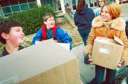 FROM LEFT, West Junior High School students Stefan Kuczera, Lucas Smith and Lilly Cottrell load some of the more than 500 canned food items that their seventh-grade class gathered in a food drive in this November 2005 file photo. Food pantries especially need nonperishable donations this time of year. Grocery store gift cards make good donations, too.