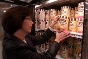 Grocery shopper Lori Blatt pulls a container of reduced-calorie ice cream from the freezer at a Hannaford supermarket in Colonie, N.Y. Producers are improving the taste of "light" products, and sales are climbing, but some nutritionists worry it may reveal Americans&squot; inability to eat in moderation.