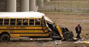 An investigator examines the scene after a bus carrying high school students smashed through a guardrail along an overpass Monday and crashed nose-first 30 feet below, killing three teenage girls and injuring at least 30 other people, several critically, in Huntsville, Ala.