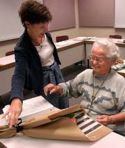 Nola Ochs, right, receives flowers from her adviser, Joleen Briggs, during her philosophy class Friday at Fort Hays State University in Hays. Ochs will be 95 on Wednesday.