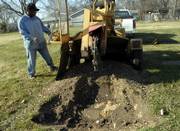 Frank Demby Jr., a Lawrence Parks and Recreation employee, operates a tree stump remover Wednesday in Memorial Park Cemetery. The city is planning to take over ownership of the cemetery on East 15th Street across from Oak Hill Cemetery. A judge has yet to rule on the ownership motion.