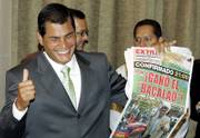 Ecuador&squot;s presidential candidate Rafael Correa smiles as he holds up a newspaper that reads "The cod wins" before a news conference in Guayaquil, Ecuador, on Monday. According to unofficial exit polls, Correa has a wide lead over Alvaro Noboa, a billionaire who is Ecuador&squot;s wealthiest man, after Sunday&squot;s runoff presidential elections.