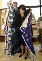 Karen Swisher, president of Haskell Indian Nations University, accepts a blanket on behalf of the Board of Regents from Regent Paul Ninham. The gift was part of a farewell reception for Swisher, who is retiring after seven years as president.