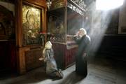A Greek Orthodox monk and another worshipper pray next to the Grotto of the Church of Nativity, traditionally believed to be the birthplace of Jesus, in Bethlehem. The ruling Palestinian Hamas party has promised to pay $50,000 for the town's Christmas decorations.