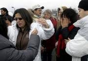 Family members of the climbers lost on Mount Hood embrace after a news conference in Hood River, Ore. Michaela Cooke, wife of Jerry Cooke, is seen at left; Lou Anne Cameron, mother of Kelly James, is shown at center with glasses; and Maria Kim, mother of Jerry Cooke, is shown with her hands to her face. Rescuers said Monday that a body found Sunday on the mountain was Kelly James.