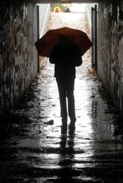A student from Broken Arrow School hustles through the tunnel under Louisiana Street after school Wednesday while sporting her umbrella for the afternoon sprinkles.