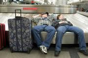 John, left, and Summer Cox, of Wilmington, Ill., rest on a Denver International Airport baggage carousel while they wait out the storm that closed the airport.
