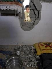Jenin Al-Masri looks into her family's house in the northern Gaza Strip town of Beit Hanoun. A Palestinian rocket aimed at Israel veered off course and struck the home Thursday, wounding a 2-year-old boy sleeping in his bedroom, hospital officials and residents said.