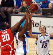 OHIO STATE'S GREG ODEN, LEFT, gets his hands on a rebound over Florida's Chris Richard, center, while the Gators' Joakim Noah watches. Florida earned a surprisingly easy 86-60 victory Saturday in a battle of top-five teams at Gainesville, Fla.