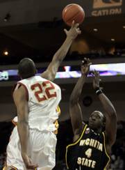 USC'S TAJ GIBSON BLOCKS A SHOT by Wichita State's Ryan Martin. The Trojans beat the Shockers,
60-56, on Saturday at the Las Vegas Classic.