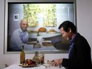 Accenture researchers Dadong Wan, right, and Adam Pilon demonstrate a video conferencing device Dec. 15 that allows families to dine together from different locations.