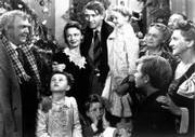 James Stewart, center, as George Bailey is reunited with his wife, played by Donna Reed, left center, their children and Uncle Billy, actor Thomas Mitchell, left, during the final scene of Frank Capra's movie "It's A Wonderful Life." Stewart has his arm around child actress Karolyn Grimes, who played his daughter Zuzu.