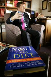 Dr. Michael F. Roizen and book collaborator, Dr. Mehmet C. Oz&squot; book "You on a Diet" rests on a table in Roizen&squot;s office as Roizen gives an interview at the Cleveland Clinic. Roizen is 60, but by the standards of his RealAge test, he&squot;s the equivalent of a 42-year-old, perhaps a few months younger.