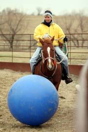 Janise Elder, Overland Park, and her horse Snickers dribble an inflatable ball along the fence line of a corral during a game at stables near Edgerton.