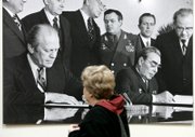 Judy Plumley, of Brighton, Mich., views a photograph of President Gerald Ford, left, and Soviet leader Leonid Brezhnev meeting in November 1974 in Vladivostok, Russia. The picture is in the Gerald R. Ford Presidential Library in Ann Arbor, Mich. Ford, the 38th U.S. president, died Tuesday at 93.