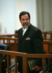 Saddam Hussein, former Iraqi president, holding the Quran, reacts as the verdict is delivered during his trial for crimes against humanity in Baghdad's heavily fortified Green Zone in this Nov. 5 file photo. Saddam Hussein was hanged today in Baghdad, Iraq.