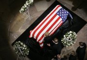 Former first lady Betty Ford, accompanied by her son Michael, prays by the casket of her husband, former President Gerald R. Ford during state funeral services Saturday on Capitol Hill in Washington. Behind are the Fords' children, from left, Steven Ford, Susan Ford and Jack Ford.