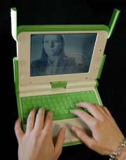 Katie Powell, of Cambridge, Mass., models a "$100 laptop" created by Massachusetts Institute of Technology professors for schoolchildren in the developing world. Powell's face is captured on the screen by the laptop camera.