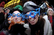 Leanne Cox, left, and Katie Surridge, both of Liverpool, England, show off their 2007 glasses while joining hundreds of thousands of New Year's Eve celebrants in Times Square on Sunday in New York.