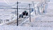 Power lines sag from heavy ice accumulation Sunday as farmers travel down a rural road near Ogallah. A winter storm, which brought heavy snow and freezing rain to the state, caused widespread power outages across much of western Kansas.