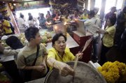Thais gather to pray at Wat Hua Lamphong Buddhist temple in Bangkok, Thailand. Life in the capital was normal Monday despite a spate of bombings Sunday that disrupted New Year's celebrations.