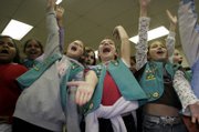 Local Girl Scouts Sarah Kinder, 10, left, Louisa Holland, 11, center, and Michaela Hernandez, 10, sing "An Alligator Can Be Your Friend," a call-and-response song led by older Girl Scouts on Friday night for the Girl Scout Cookie Kick-Off. About 450 girls attended the event at the Douglas County 4-H Fairgrounds.