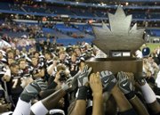 university of cincinnati football players celebrate with the International Bowl trophy. The Bearcats beat the Western Michigan Broncos, 27-24, Saturday in Toronto.