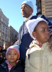 Wesley Autrey stands with his two daughters Syshe, 4, left, and Shuqui, 6, at the Broadway and 145th Street subway stop in New York shortly after he saved the life of a teenager who fell onto tracks in front of an oncoming train Tuesday.