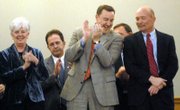 Kansas Insurance Commissioner Sandy Praeger, left, applauds Attorney General Paul Morrison, right, with Secretary of State Ron Thornburgh during Morrison's introduction. The three were in attendance Wednesday for Gov. Kathleen Sebelius' State of the State speech.