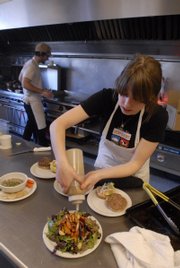 Jessica Thompson drizzles balsamic vinaigrette onto a roasted veggie salad as Clinton Jackson watches the grill at Local Burger. The restaurant will be the focus of a Sundance Channel TV show.